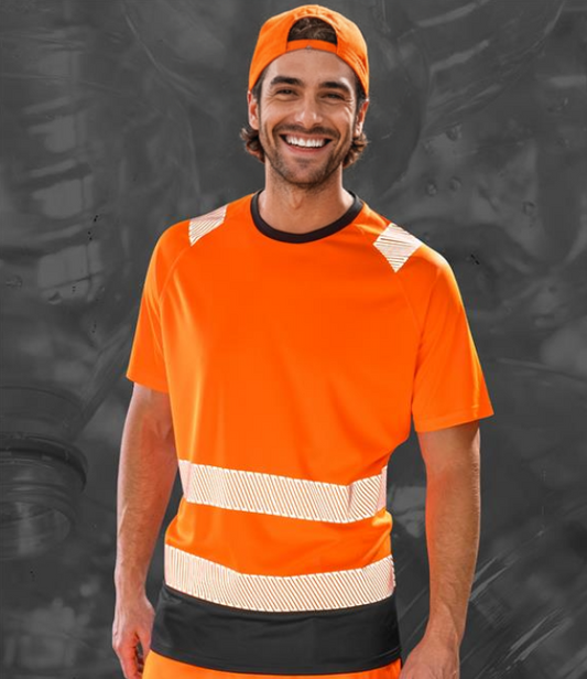 A person wearing a short-sleeved fluorescent orange safety t-shirt with reflective bands and a cap matching the t-shirt.