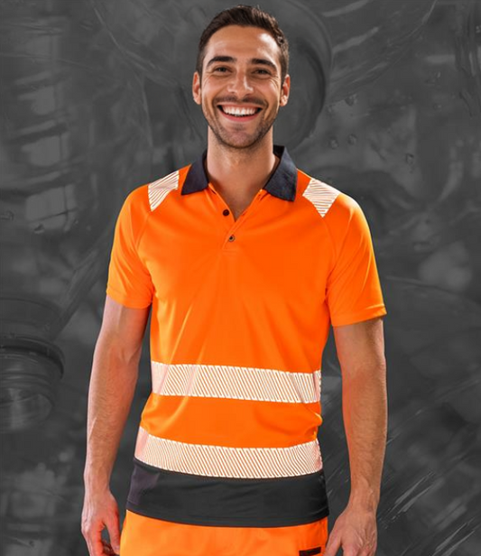 A man wearing a fluorescent orange safety polo shirt with black and white stripes on the sleeves and reflective safety stripes around the body.
