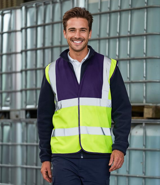 A person wearing a yellow and purple high visibility waistcoat with reflective bands.